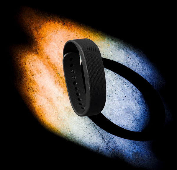 SilentRise Pro wristband alarm worn on wrist — escalating vibration levels for heavy sleepers